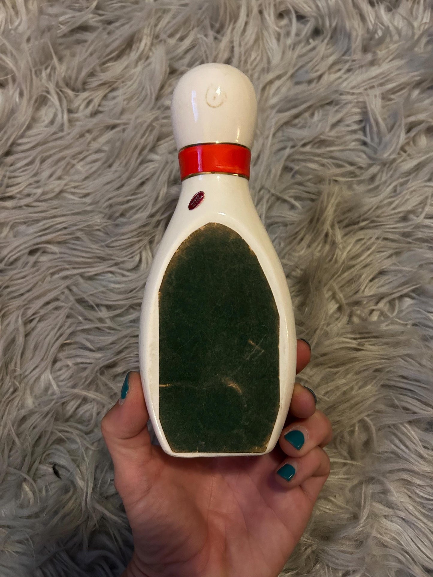 novelty bowling pin shaped ashtray with red band and gold trim.