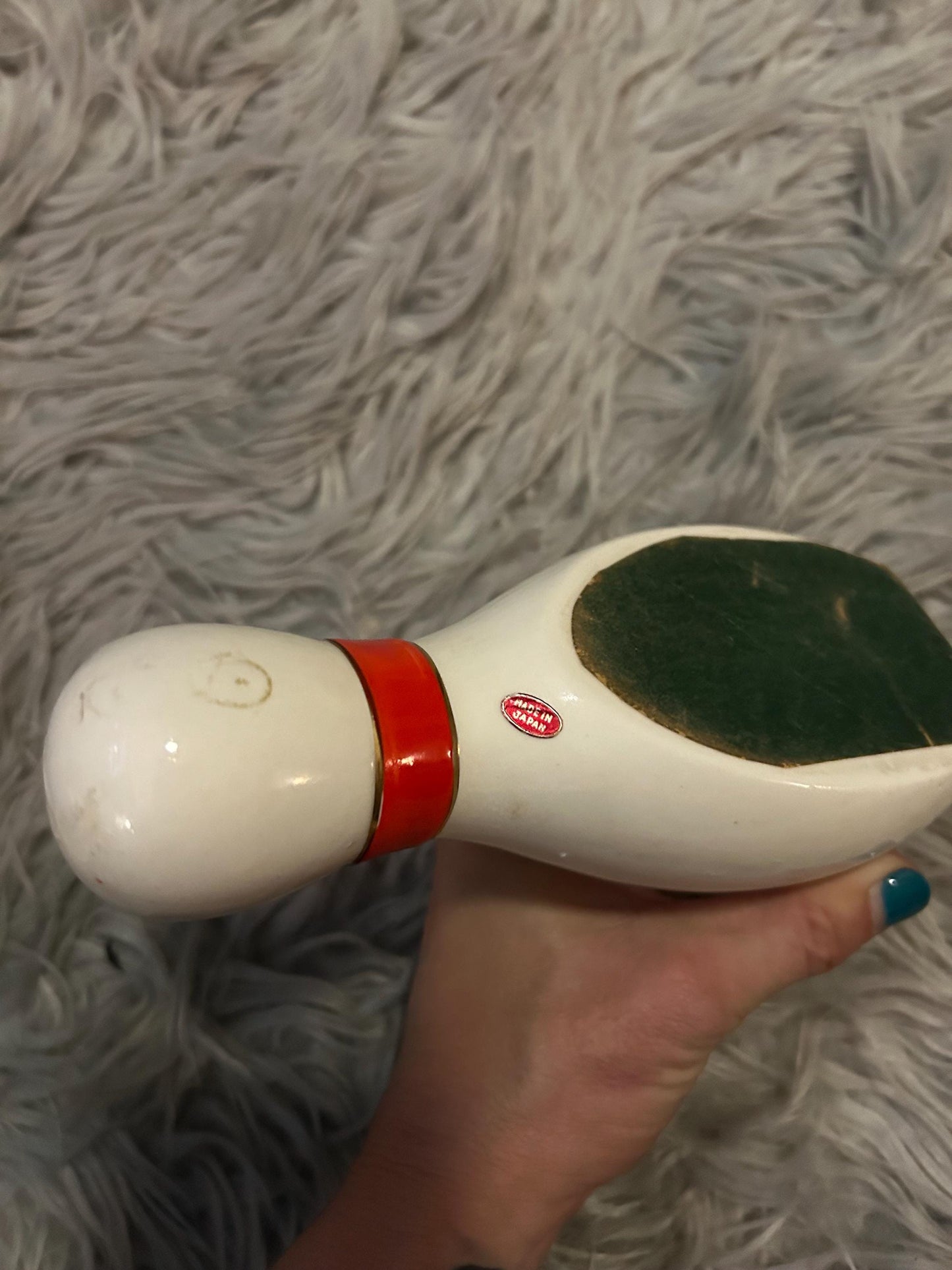 novelty bowling pin shaped ashtray with red band and gold trim.