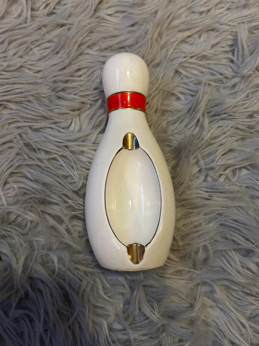 novelty bowling pin shaped ashtray with red band and gold trim.